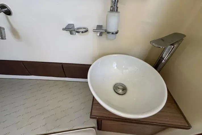 Slide: The Image of 2018 Chris-Craft Catalina 30 bathroom sink with modern fixtures and wooden accents. - 19