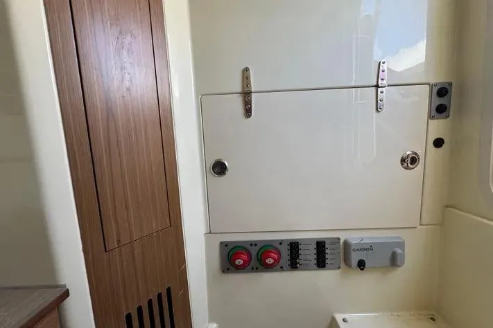 Slide: The Image of 2018 Chris-Craft Catalina 30 interior panel with controls and wooden accents. - 21