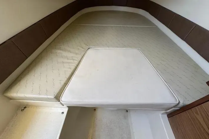 Slide: The Image of 2018 Chris-Craft Catalina 30 interior cabin with cushioned seating and wooden accents. - 25