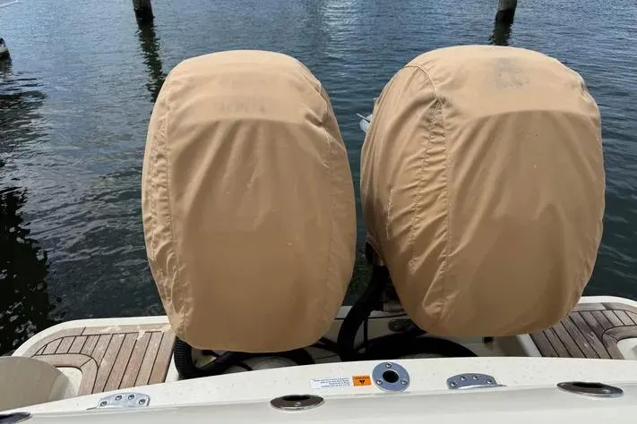 Slide: The Image of 2018 Chris-Craft Catalina 30 with covered outboard motors on a wooden deck. - 31