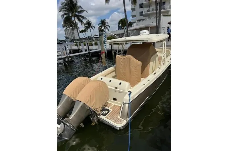 Slide: The Image of 2018 Chris-Craft Catalina 30 boat docked, covered engines, palm trees in background. - 4