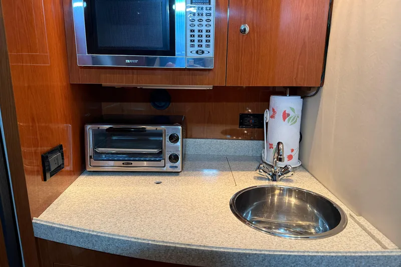 Slide: The Image of 2007 Regal Commodore 3760 IO yacht kitchenette with microwave, toaster oven, and sink. - 13