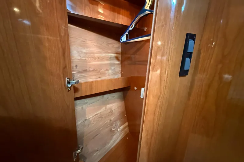 Slide: The Image of Wooden closet interior on 2007 Regal Commodore 3760 IO boat, featuring hangers and shelves. - 22