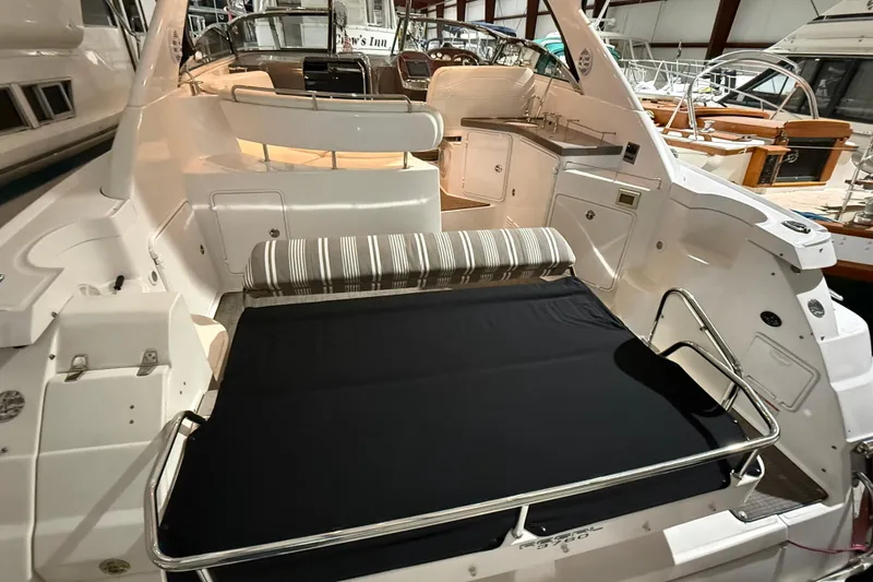 Slide: The Image of 2007 Regal Commodore 3760 IO boat interior with seating and kitchenette in a marina setting. - 3