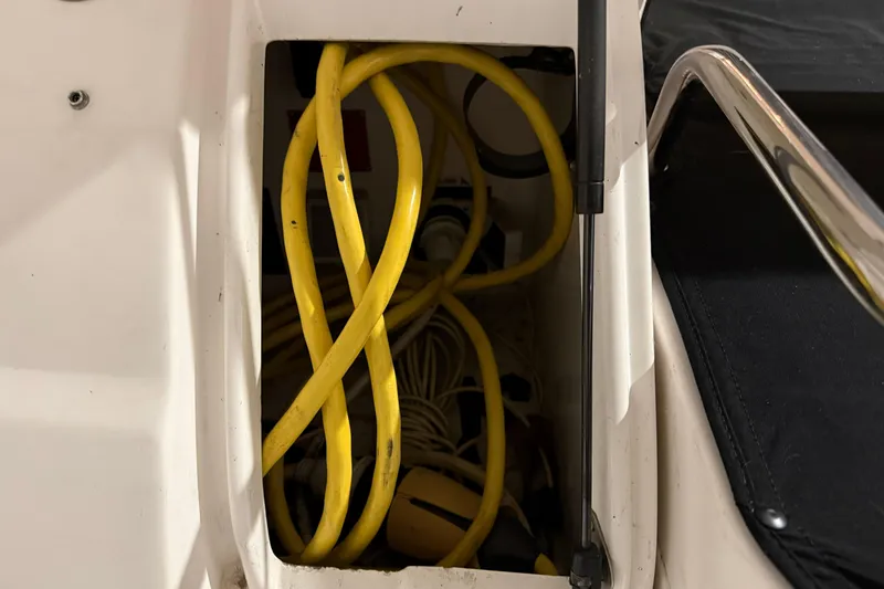 Slide: The Image of Storage compartment with yellow cables on a 2007 Regal Commodore 3760 IO boat. - 43