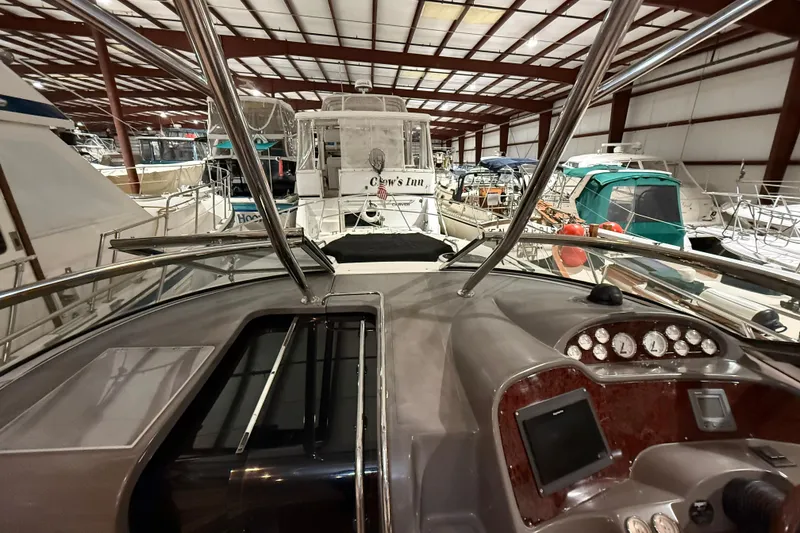 Slide: The Image of 2007 Regal Commodore 3760 IO yacht interior, showcasing dashboard and marina setting. - 7