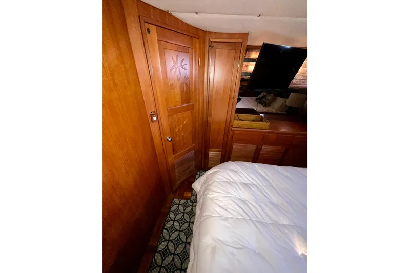 Slide: The Image of 1987 Lien Hwa 47 Cockpit Motor Yacht interior with wooden door and cozy bedroom. - 12