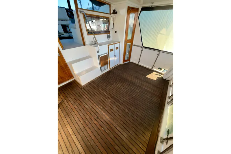 Slide: The Image of 1987 Lien Hwa 47 Cockpit Motor Yacht interior with wooden flooring and seating area. - 20