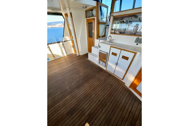 Slide: The Image of 1987 Lien Hwa 47 Cockpit Motor Yacht interior with wooden flooring and kitchenette. - 21