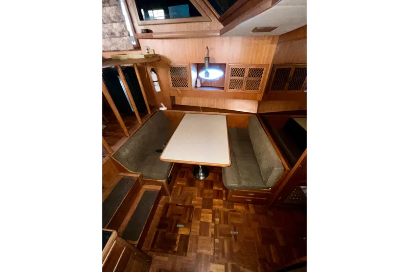 Slide: The Image of 1987 Lien Hwa 47 Cockpit Motor Yacht interior with wood finish and dining area. - 7