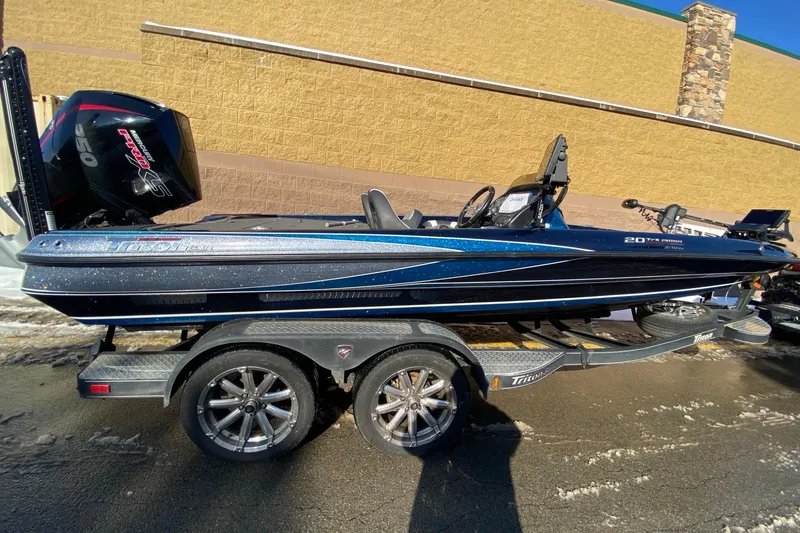 Slide: The Image of 2020 Triton 20 TrX Patriot boat on trailer, sleek design, powerful engine. - 1
