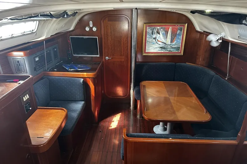 Slide: The Image of Interior of 1994 Beneteau Oceanis 400 sailboat with wood finish and cozy seating area. - 12