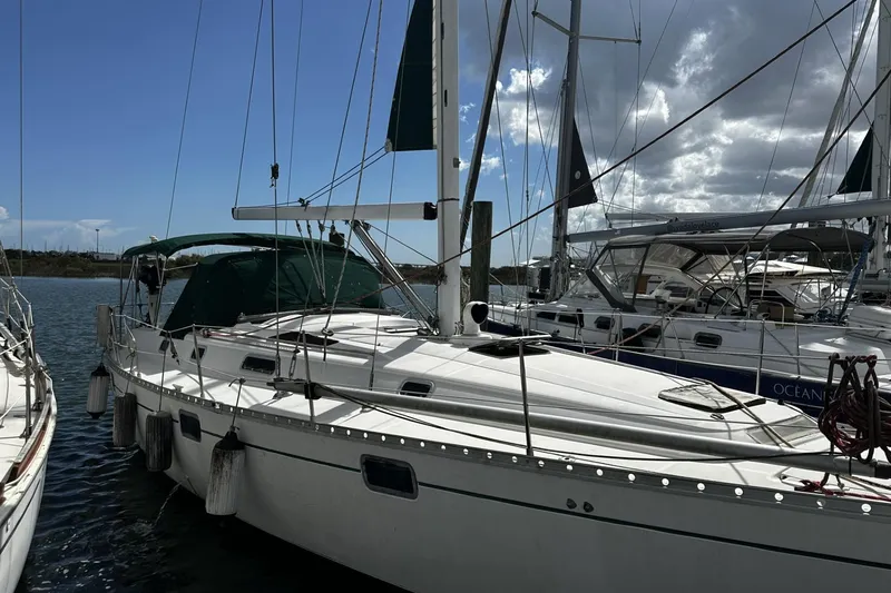Slide: The Image of 1994 Beneteau Oceanis 400 sailboat docked at marina under cloudy sky. - 2