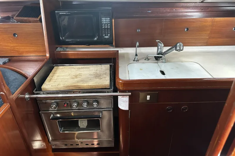 Slide: The Image of Galley kitchen in 1994 Beneteau Oceanis 400 sailboat with stove, microwave, and sink. - 21