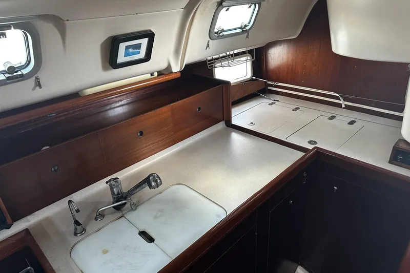 Slide: The Image of Interior of 1994 Beneteau Oceanis 400 yacht, featuring a compact kitchen area. - 22