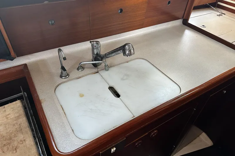 Slide: The Image of 1994 Beneteau Oceanis 400 yacht kitchen sink with wooden cabinetry and countertop. - 23