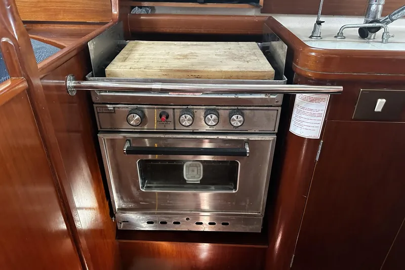 Slide: The Image of 1994 Beneteau Oceanis 400 yacht kitchen with stainless steel oven and wooden countertop. - 24