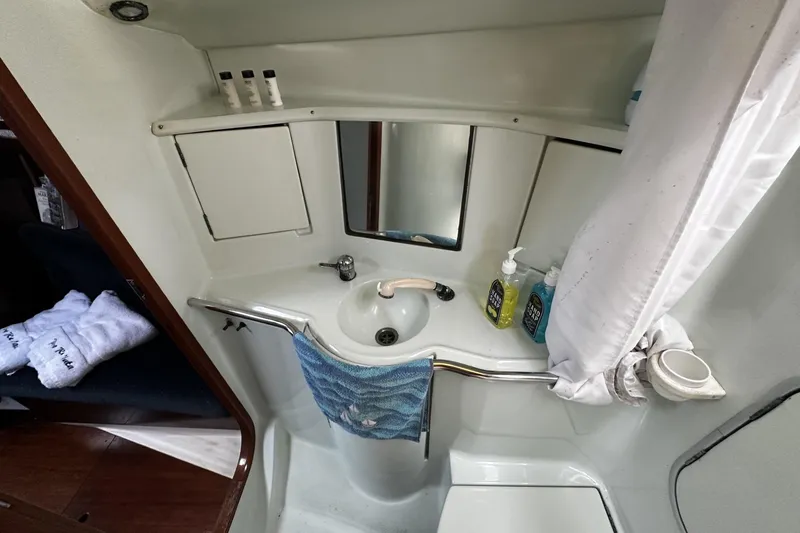 Slide: The Image of Bathroom interior of 1994 Beneteau Oceanis 400 yacht with sink, mirror, and toiletries. - 32