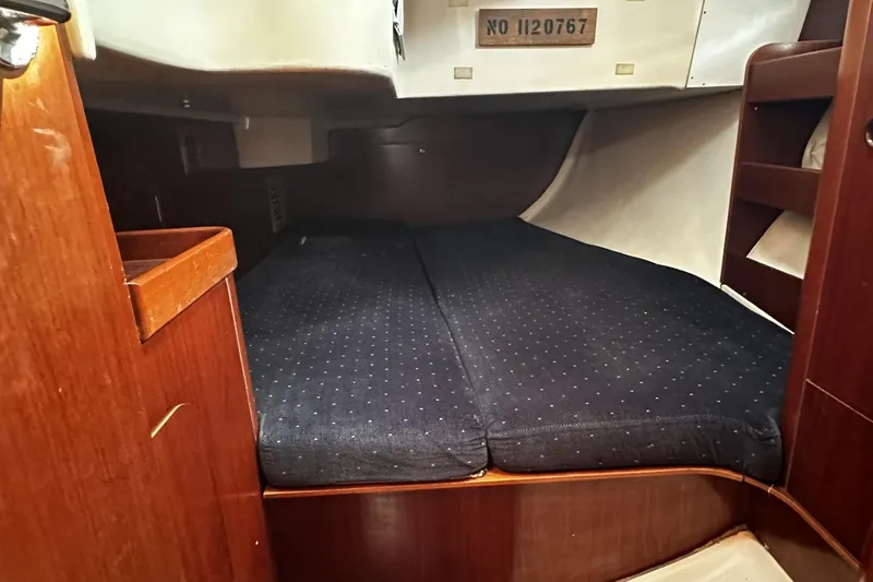 Slide: The Image of Cozy cabin interior of 1994 Beneteau Oceanis 400 sailboat with dark cushioned bed. - 33