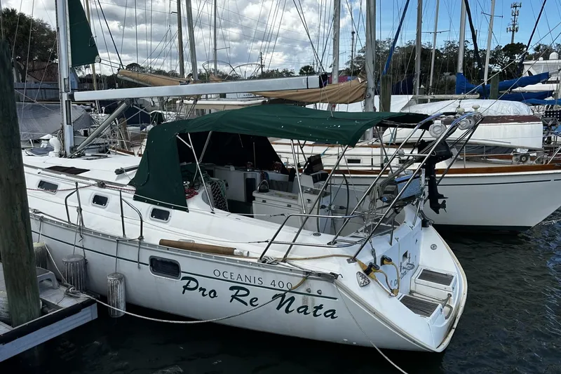 Slide: The Image of 1994 Beneteau Oceanis 400 sailboat docked at marina, featuring green canopy. - 42