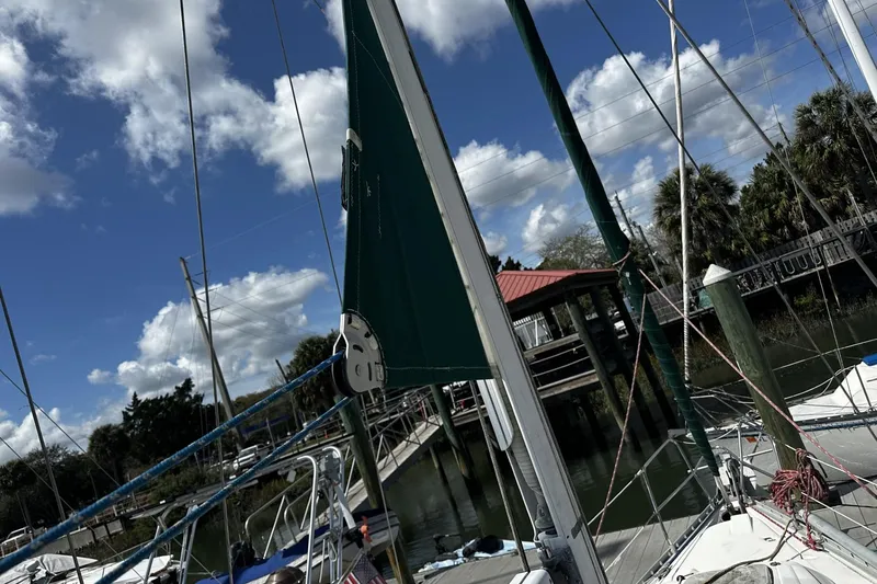 Slide: The Image of Sailboat Beneteau Oceanis 400, 1994 model, docked under a blue sky with clouds. - 48