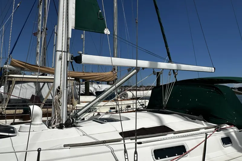 Slide: The Image of 1994 Beneteau Oceanis 400 sailboat docked, featuring green sail cover and rigging. - 5