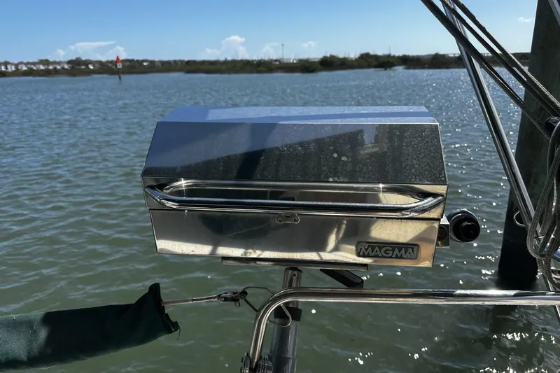 Slide: The Image of Stainless steel Magma grill on a 1994 Beneteau Oceanis 400 sailboat, overlooking calm waters. - 52