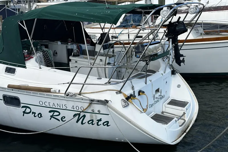 Slide: The Image of 1994 Beneteau Oceanis 400 sailboat docked, featuring green canopy and "Pro Re Nata" name. - 6