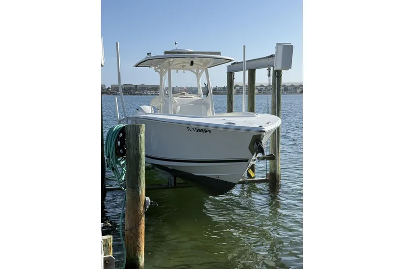 The Image of 2013 Jupiter 30 boat on lift, docked by waterfront homes. - 0