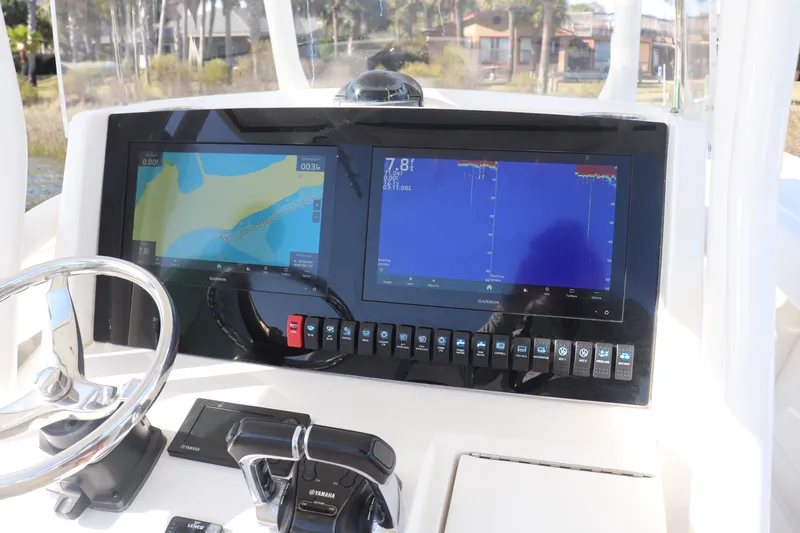 Slide: The Image of Control panel of a 2013 Jupiter 30 boat with navigation screens and steering wheel. - 11