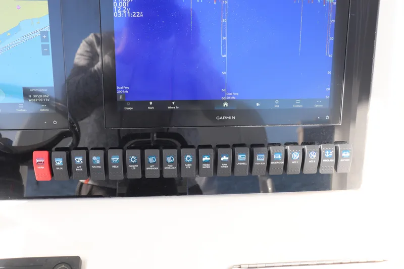 Slide: The Image of Control panel of a 2013 Jupiter 30 boat with Garmin display and switches. - 12