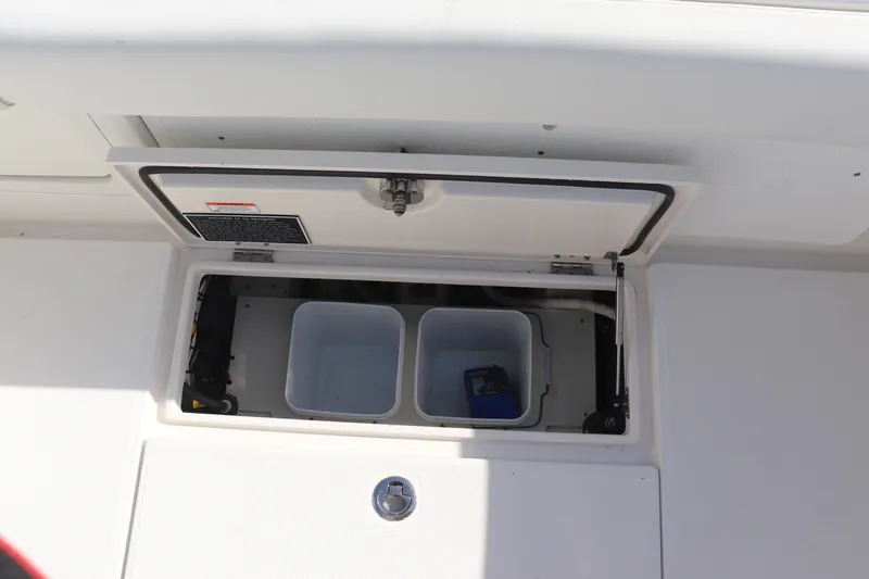 Slide: The Image of Open storage compartment on a 2013 Jupiter 30 boat, featuring two bins. - 16