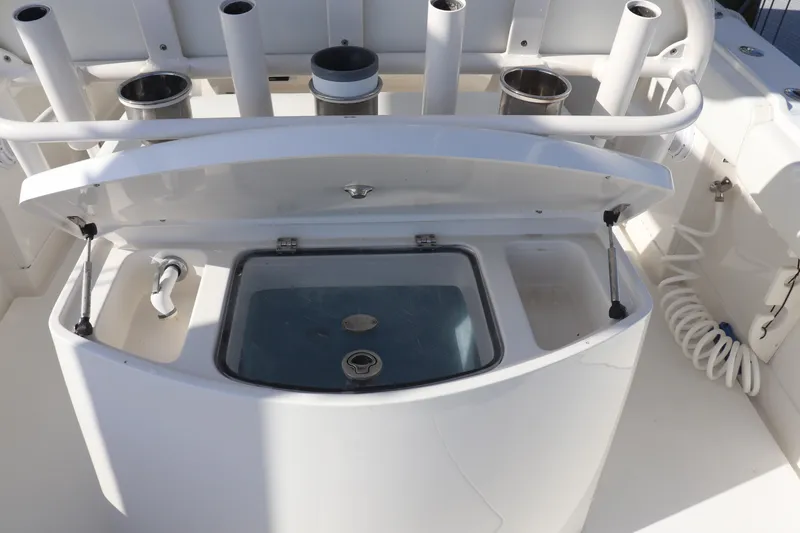 Slide: The Image of Open storage compartment on 2013 Jupiter 30 boat with rod holders and coiled hose. - 17