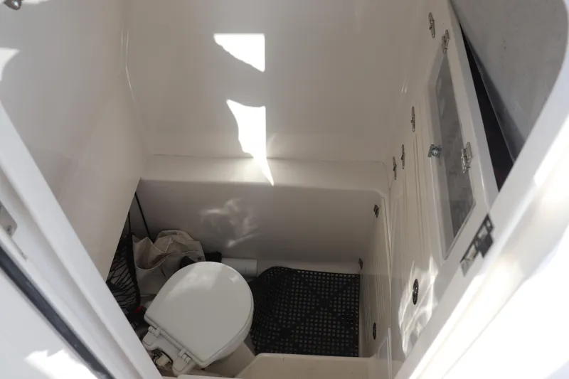 Slide: The Image of Compact marine bathroom in 2013 Jupiter 30 boat, featuring a toilet and storage area. - 19