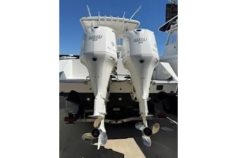 Slide: The Image of Twin outboard engines on a 2013 Jupiter 30 boat, docked under clear skies. - 2