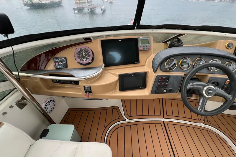 Slide: The Image of 2003 Carver 444 Cockpit Motor Yacht helm with navigation instruments and steering wheel. - 16