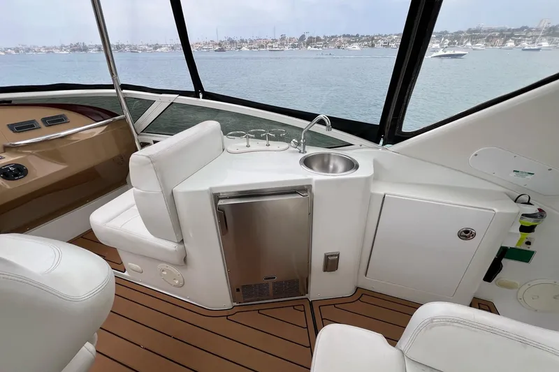 Slide: The Image of 2003 Carver 444 Cockpit Motor Yacht interior with sink and seating, overlooking marina. - 22