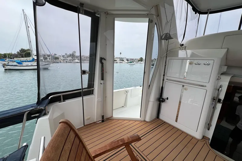 Slide: The Image of 2003 Carver 444 Cockpit Motor Yacht interior with wooden deck and marina view. - 25
