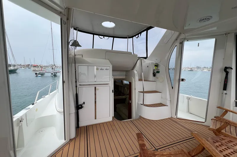 Slide: The Image of 2003 Carver 444 Cockpit Motor Yacht interior with wooden flooring and marina view. - 26