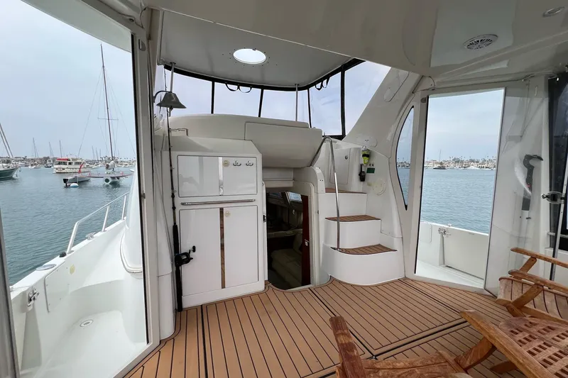 Slide: The Image of 2003 Carver 444 Cockpit Motor Yacht interior with wooden deck and marina view. - 27