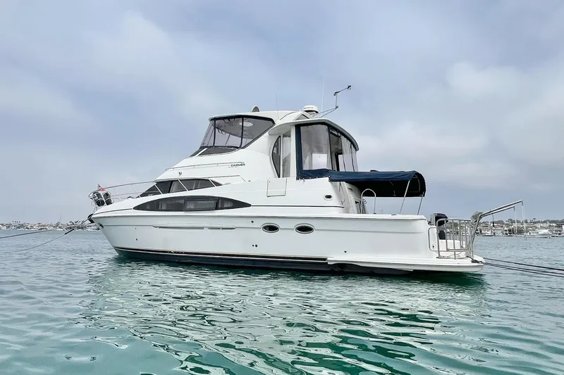Slide: The Image of 2003 Carver 444 Cockpit Motor Yacht on calm water under a cloudy sky. - 3