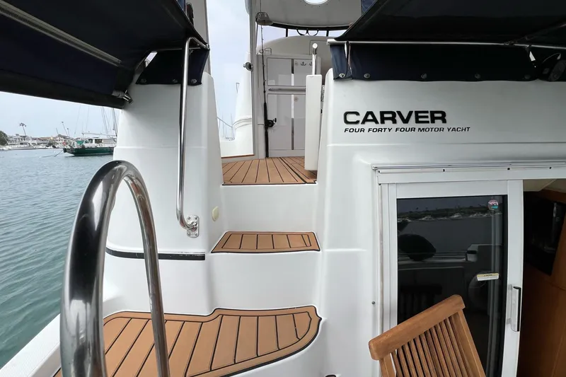 Slide: The Image of 2003 Carver 444 Cockpit Motor Yacht with teak steps and marina view. - 32