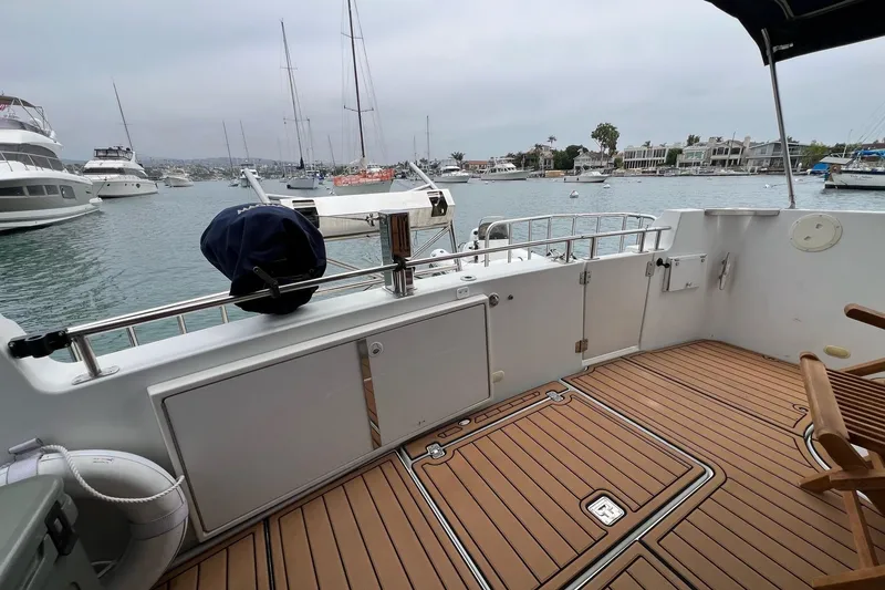 Slide: The Image of 2003 Carver 444 Cockpit Motor Yacht docked in a marina, featuring spacious deck and scenic view. - 37