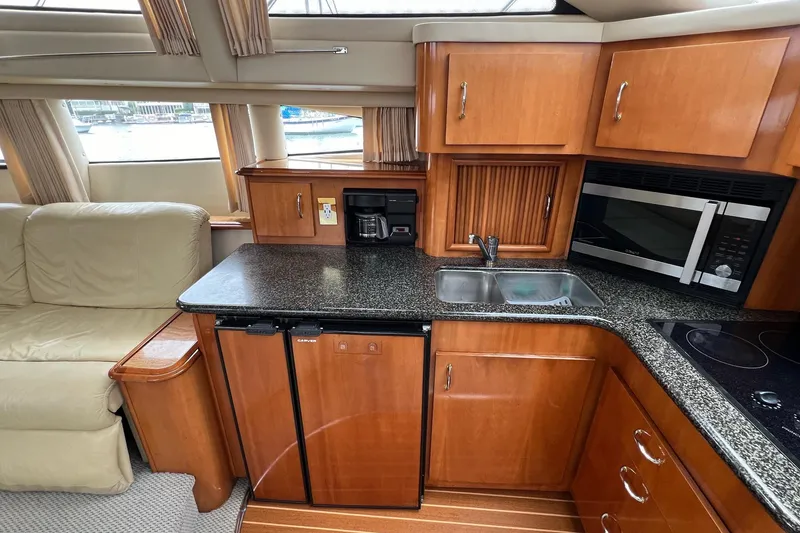 Slide: The Image of 2003 Carver 444 Cockpit Motor Yacht interior with kitchen and seating area. - 47