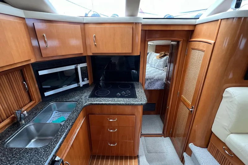 Slide: The Image of 2003 Carver 444 Cockpit Motor Yacht interior with kitchen and cozy bedroom. - 49