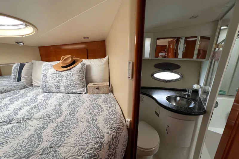 Slide: The Image of 2003 Carver 444 Cockpit Motor Yacht interior with bed, bathroom, and elegant decor. - 52