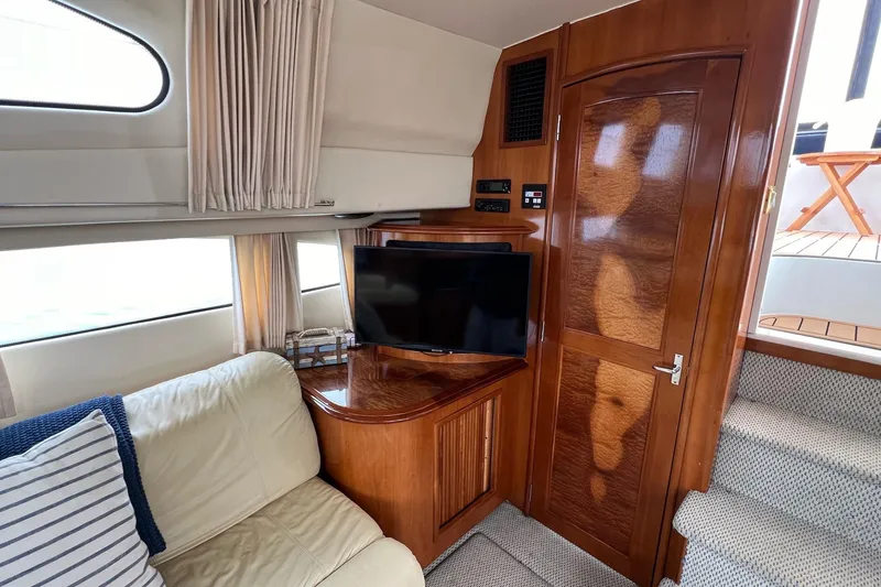 Slide: The Image of Interior of 2003 Carver 444 Cockpit Motor Yacht with TV, sofa, and wooden cabinetry. - 55