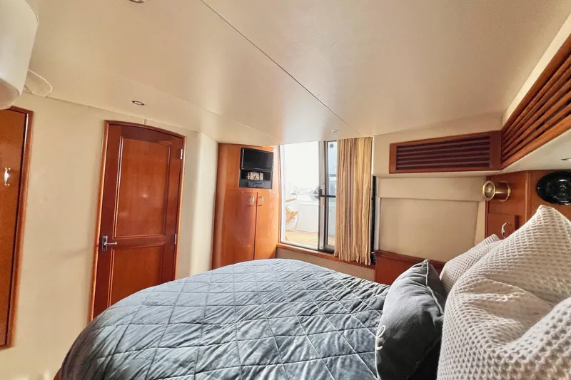 Slide: The Image of Luxurious bedroom interior of 2003 Carver 444 Cockpit Motor Yacht with wood accents. - 59