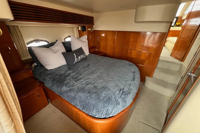 Slide: The Image of Luxurious bedroom interior of 2003 Carver 444 Cockpit Motor Yacht with plush bedding and wood cabinetry. - 61
