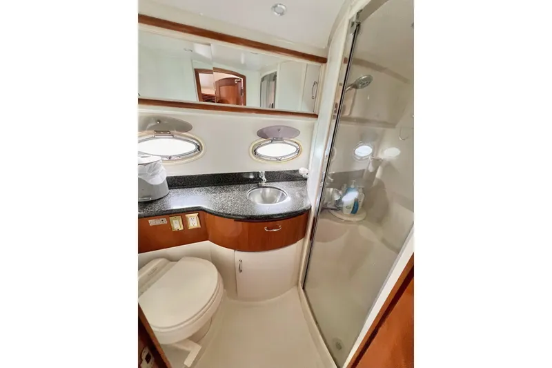 Slide: The Image of 2003 Carver 444 Cockpit Motor Yacht bathroom with shower, sink, and toilet. - 62